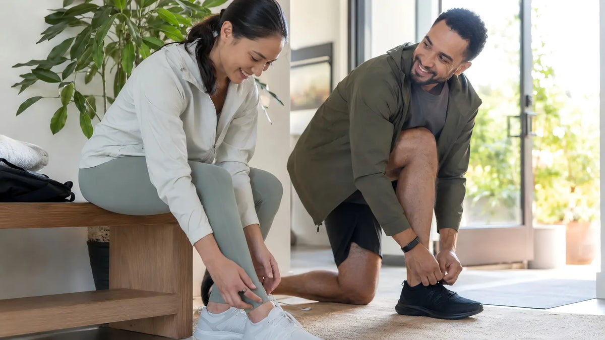 Two adults preparing for a walk, one wearing a smart ring and one wearing a fitness band